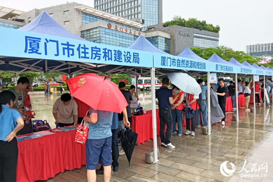 雖然大雨滂沱，但46家參與單位的工作人員依然熱情滿滿，為前來咨詢的市民群眾耐心解答問題。人民網(wǎng)記者 陳博攝