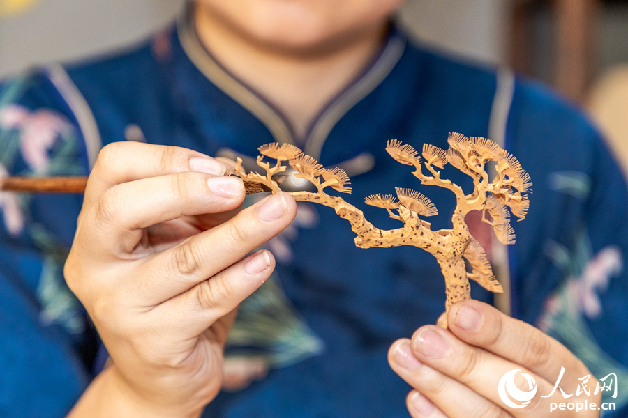 制作軟木畫(huà)要在薄如蟬翼的樹(shù)皮上純手工刻畫(huà)人物、山水、花鳥(niǎo)、亭臺(tái)、樓閣，最細(xì)微的部件薄至0.1微米。人民網(wǎng) 楊灝昱攝