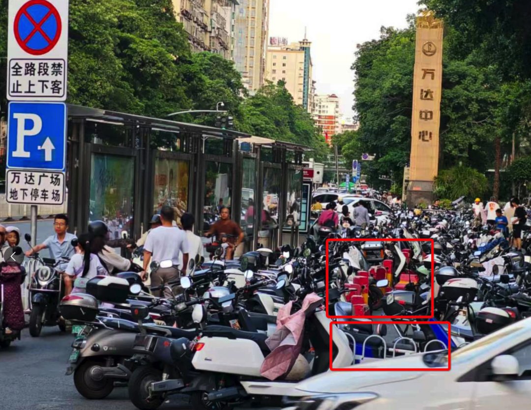 浦西公交站背后路段設(shè)置了非機(jī)動車停車區(qū)域，但仍有大量電動車直接停放在白色護(hù)欄和紅色隔離墩（紅框位置）外的非機(jī)動車道上。李先生攝于7月2日