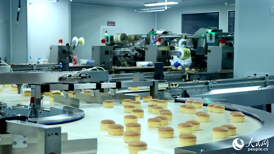 位于龍海區(qū)的一家食品企業(yè)里，制作完成的糕點經(jīng)過全自動化生產(chǎn)線進入包裝工序。人民網(wǎng) 李昌乾攝