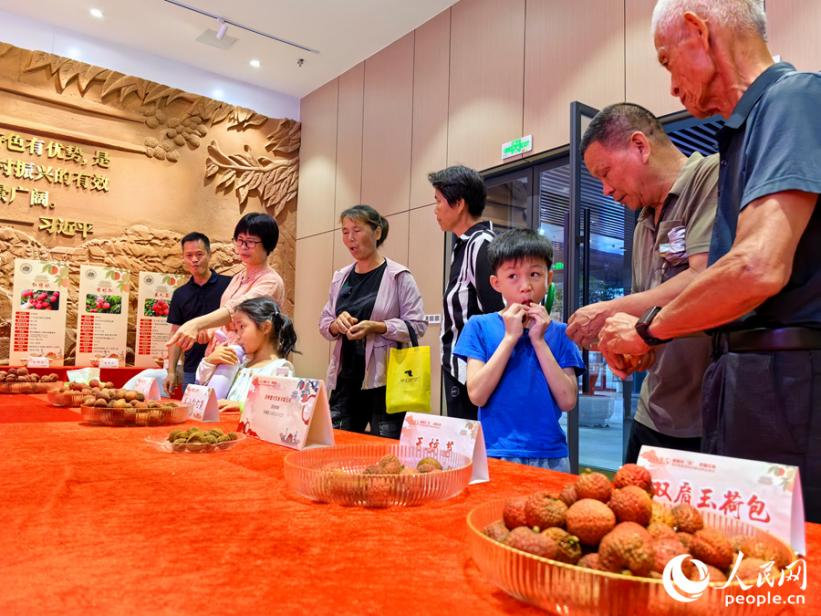 參與者在品嘗各品種荔枝。人民網(wǎng) 蘇海森攝