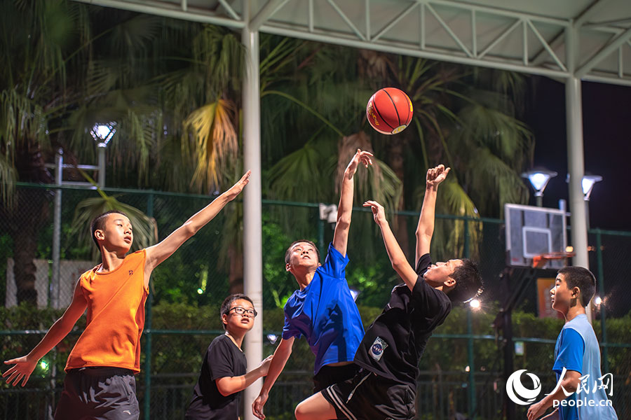 7月15日，位于福建福州的福建省奧林匹克體育中心，一群孩子正在夜色下打籃球。實(shí)習(xí)生 魏建燁攝