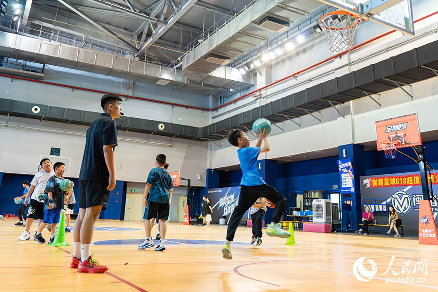7月13日，位于福建晉江的安踏全民健身運(yùn)動(dòng)中心籃球館內(nèi)，學(xué)生在暑期籃球訓(xùn)練營(yíng)中進(jìn)行籃球基本功訓(xùn)練。實(shí)習(xí)生 林靜茹攝