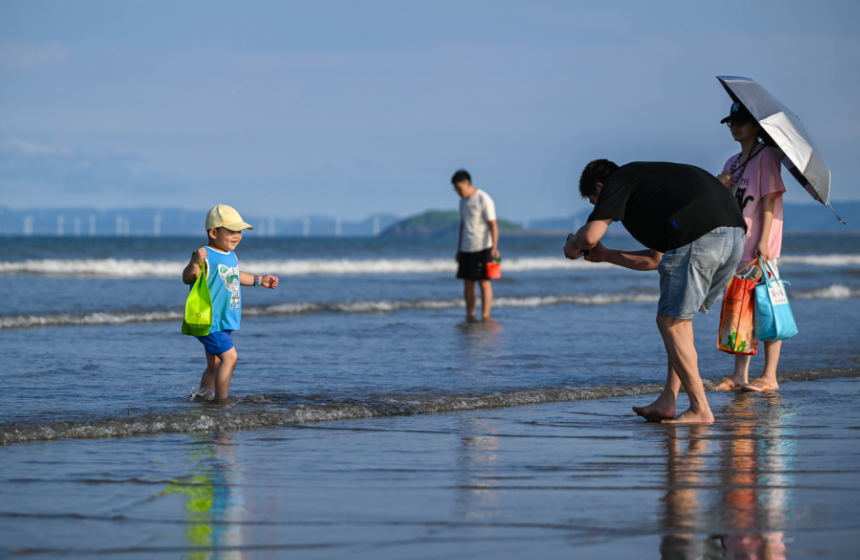小朋友“全副武裝”在海邊玩水。林雙偉攝