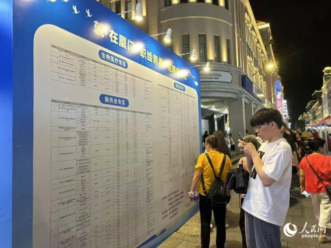 活動(dòng)現(xiàn)場(chǎng)，求職者正在記錄招聘信息。人民網(wǎng)記者 張萌攝