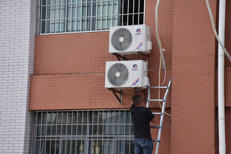工人趕在開學前為沙建中心小學教室安裝空調(diào)。蔡明進攝