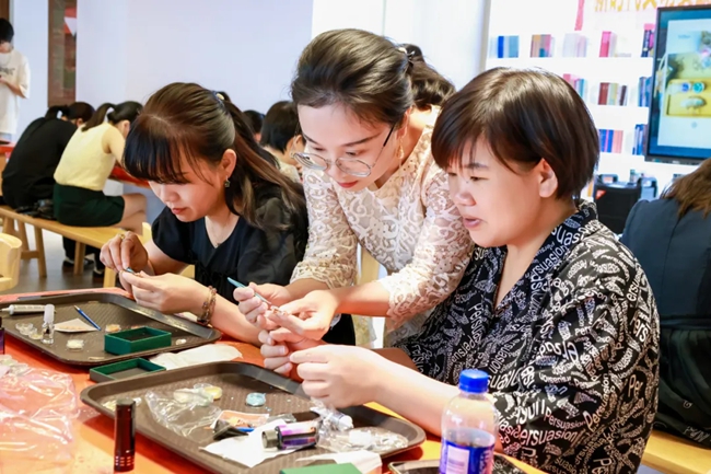 老師指導參與活動的職工進行螺鈿胸針制作