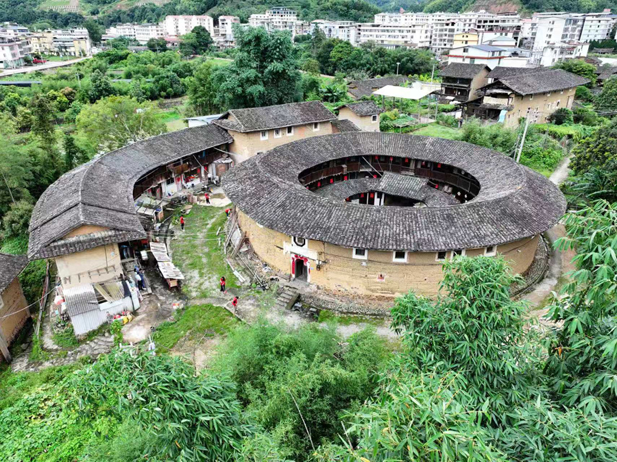 在書洋鎮(zhèn)鵝冠樓前，身著紅色馬甲的文明實踐隊開展人居環(huán)境整治。南靖縣融媒體中心供圖