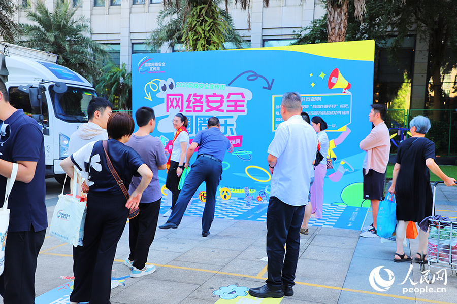 市民在“網(wǎng)絡安全進社區(qū)”活動現(xiàn)場排隊體驗網(wǎng)絡安全科普小游戲。人民網(wǎng) 黃東儀攝