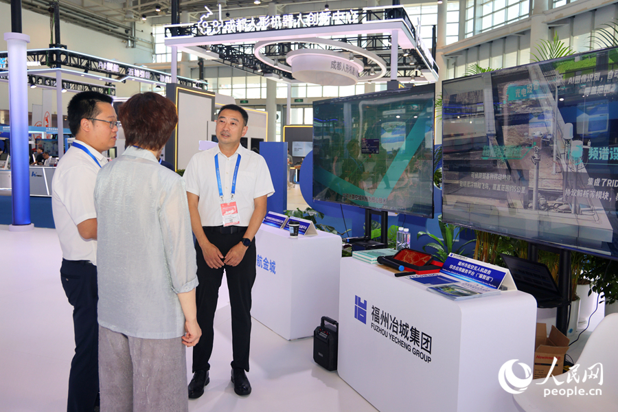 觀眾在企業(yè)展位前參展、駐足交談。人民網(wǎng)記者 陳博攝