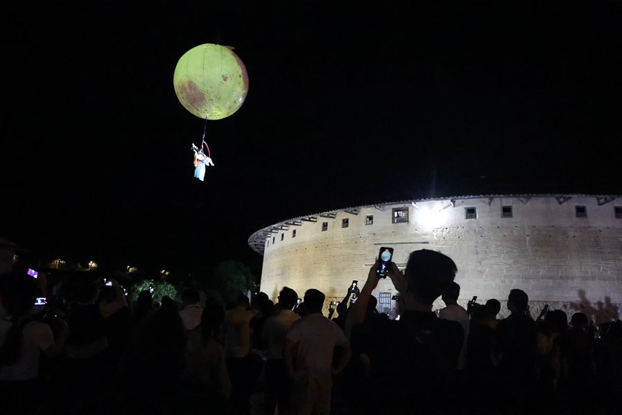 土樓上方進行的表演吸引游客拍照打卡。華安縣融媒體中心供圖