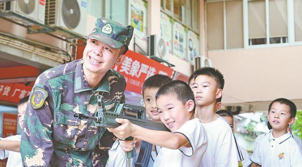 老兵在指導(dǎo)小營員進(jìn)行射擊體驗。