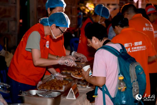 現(xiàn)場邀請“文明合伙人”——新市民品嘗在地老味道。人民網(wǎng)記者 陳博攝