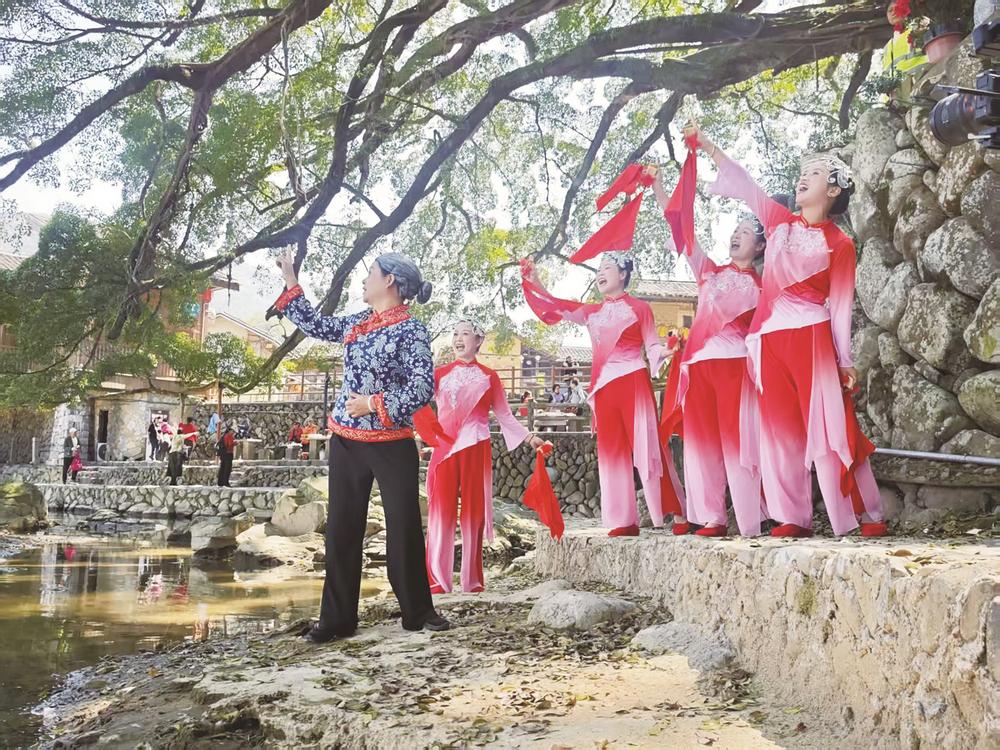 “土樓紅妹子”在南靖云水謠景區(qū)用快板表演《土樓人民笑開顏》。