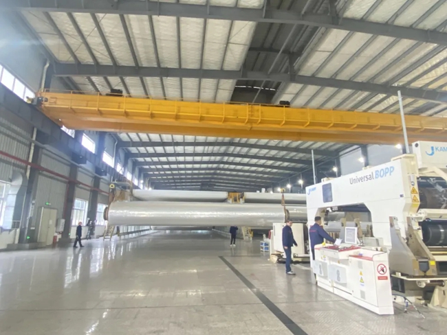 生產(chǎn)車間里機器轟鳴，工人正在有序作業(yè)