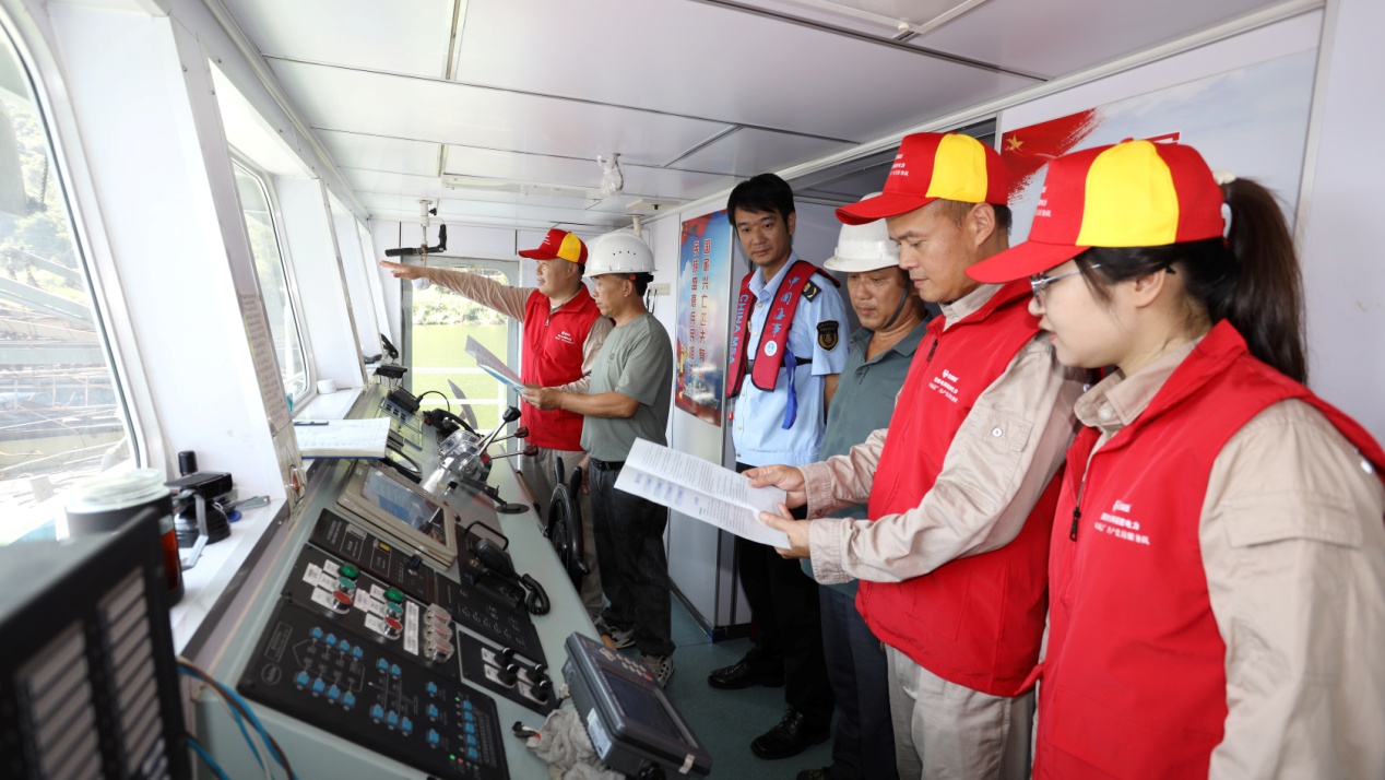 隊(duì)員們登上船頭，向船民發(fā)放《船舶安全航行手冊(cè)》。