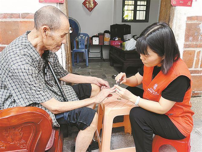 海滄區(qū)新陽街道霞陽社區(qū)助老員入戶關(guān)心關(guān)愛老年人。