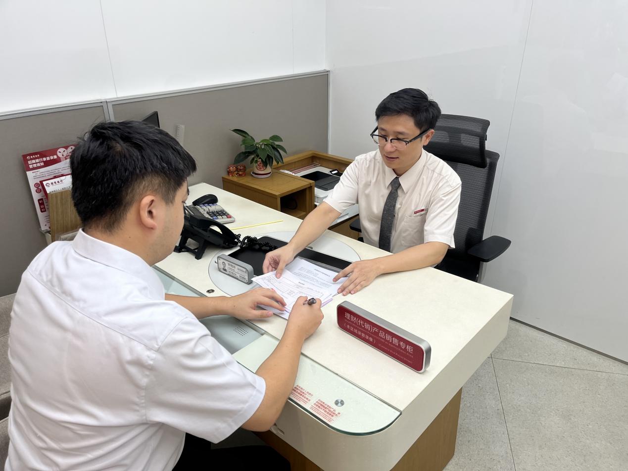 招商銀行泉州分行順利辦結(jié)首筆個人住房公積金貸款，市民吳先生（左）成為這項服務(wù)的第一位體驗者。