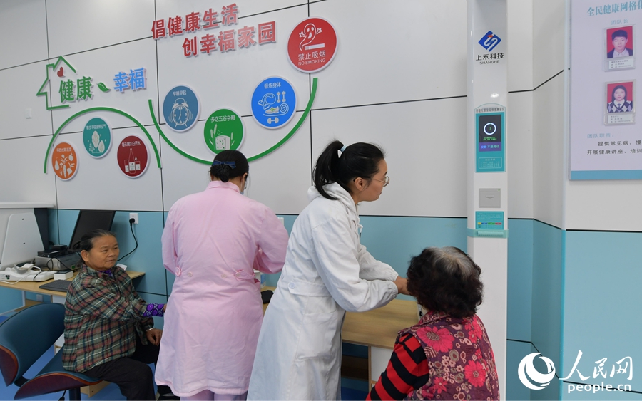 醫(yī)務(wù)人員在社區(qū)健康小屋為老人量血壓、測(cè)血糖。人民網(wǎng)記者 李昌乾攝