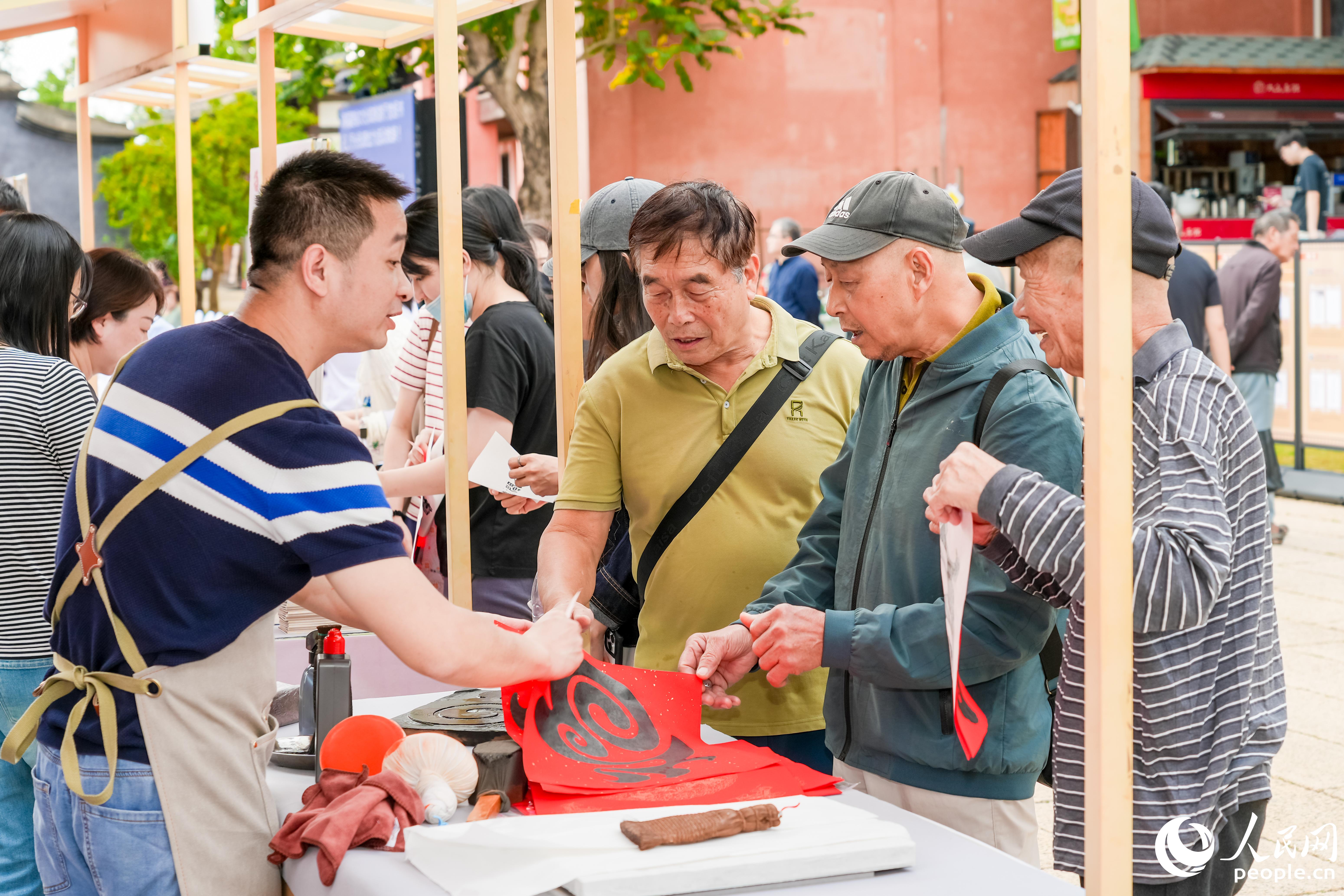市民在“八閩書房”書香市集體驗(yàn)雕版印刷。人民網(wǎng)攝