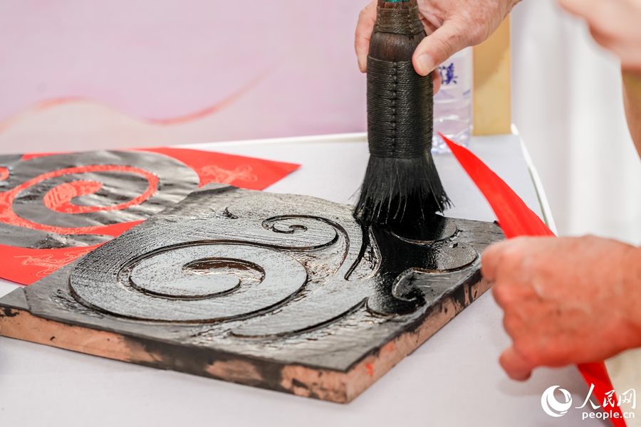 “八閩書房”書香市集設(shè)置的雕版印刷體驗(yàn)項(xiàng)目。人民網(wǎng)攝