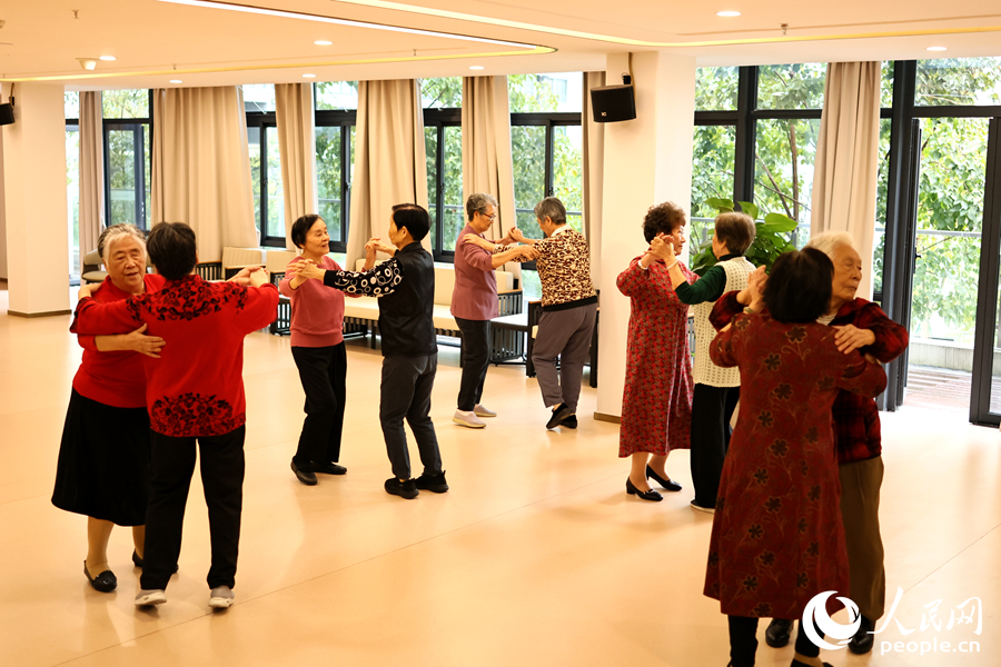 百齡之家的老人們?cè)跇?lè)活中心跳舞。人民網(wǎng)記者 李昌乾攝