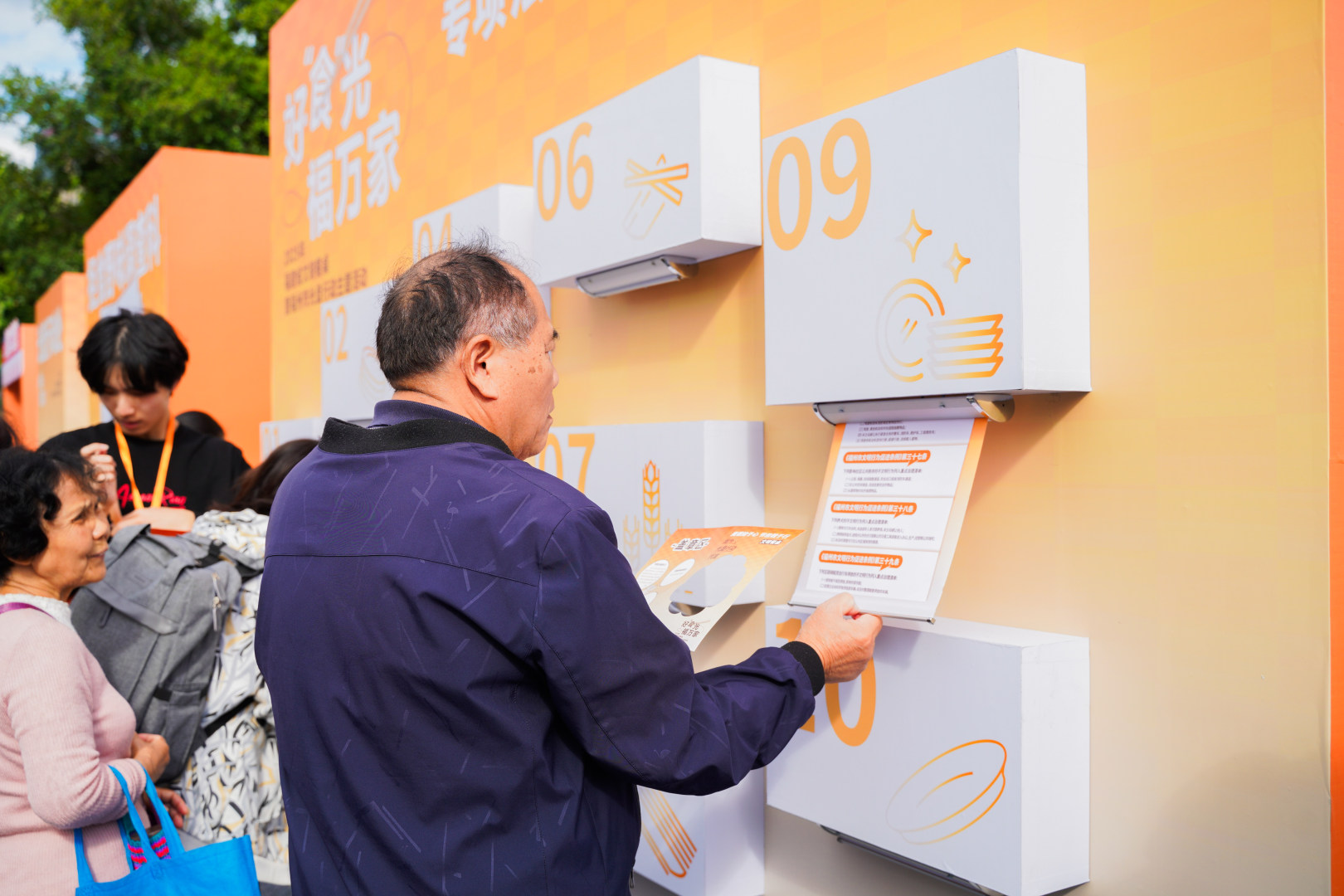 在”專(zhuān)項(xiàng)法規(guī)學(xué)習(xí)宣傳盲盒“展區(qū)，市民正在認(rèn)真查看《福州市文明行為促進(jìn)條例》。