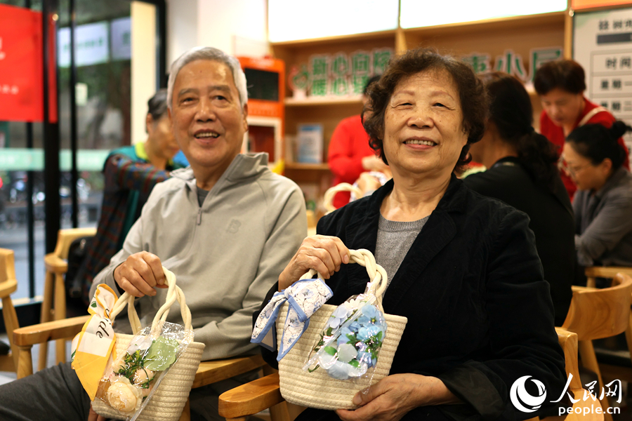 社區(qū)老人展示自制編織包成品。人民網(wǎng)記者 李昌乾攝