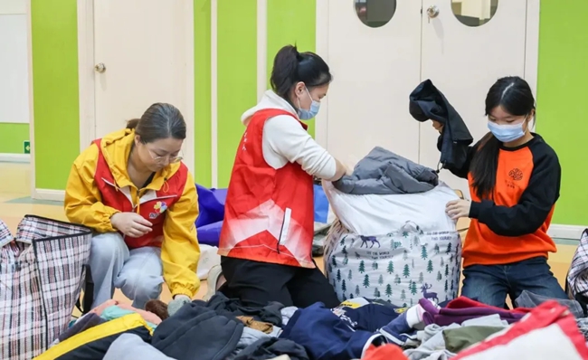 志愿者對衣物進行分類整理打包
