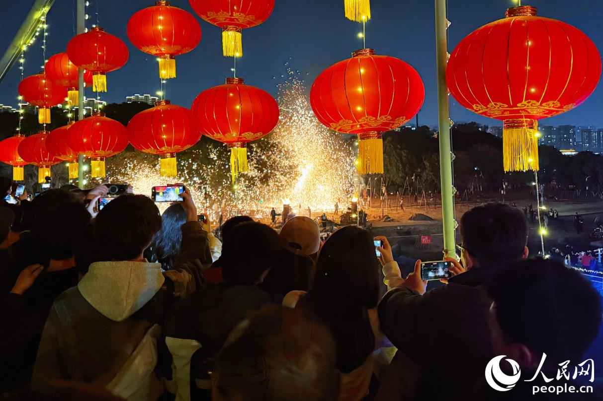 市民游客拿起手機拍攝記錄打鐵花。人民網(wǎng)記者 李唯一攝