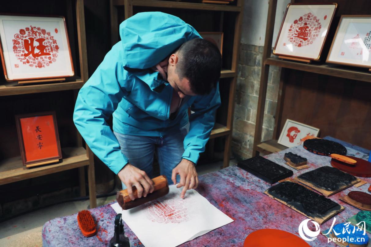 游客體驗雕版印刷。人民網(wǎng)記者 李唯一攝